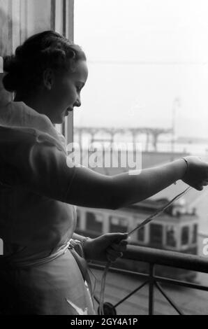 Die Prinzessin der Fastnacht in Mainz, Hildegard Kühne im Jahre 1938 beim Blick aus einem Fenster der Stadthalle, zum hundertjährigen Jubiläum des Mainzer Carneval Verein (MCV). Die Prinzessin von Karneval in Mainz 1938, anlässlich des 100. Jahrestages der führenden lokalen Karnevalsverein, schauen aus dem Fenster. Stockfoto