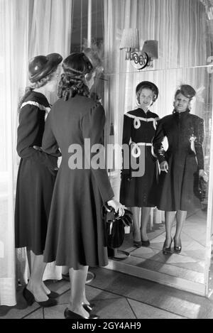 Zwei Modelle bei der Anprobe von Kleidern von Modeschöpferin Annemaria Geise; Deutschland Ca. 1939. Zwei Modelle, die versuchen, Kleider Mode Designer Annemaria Geise; Deutschland Ca. 1939. Stockfoto