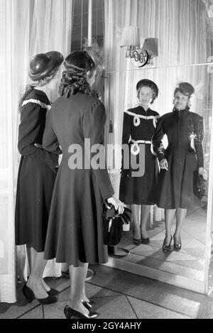 Zwei Modelle bei der Anprobe von Kleidern von Modeschöpferin Annemaria Geise; Deutschland Ca. 1939. Zwei Modelle, die versuchen, Kleider Mode Designer Annemaria Geise; Deutschland Ca. 1939. Stockfoto