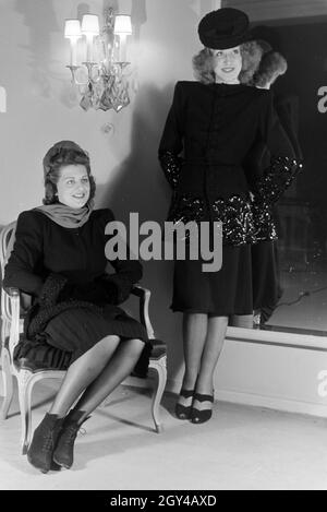 Zwei Modelle bei der Anprobe von Kleidern der Berliner Modeschöpferin Hilda Romatzki, Deutschland ca. 1939. Zwei Models versuchen Kleider der Modedesignerin Hilda Romatzki, Deutschland ca. 1939. Stockfoto