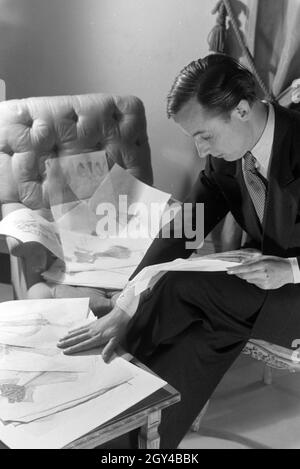 Der Modeschöpfer Heinz Schulze-Bibernell bei der Sichtung Thunfischwadenfänger Entwurfsskizzen, Deutschland Ca. 1939. Die Fashion Designer Heinz Schulze-Bibernell an seinem Design Skizzen suchen, Deutschland Ca. 1939. Stockfoto