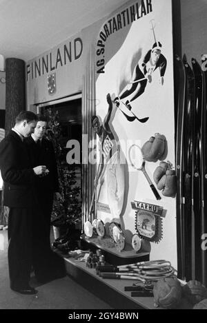 Zwei Besucher vor einem Ständer mit finnischen Sportartikeln auf der Leipziger Frühjahrsmesse, Deutschland 1941. Zwei Besucher vor einem stand der finnischen Sport waren auf der Leipziger Frühjahrsmesse, Deutschland 1941. Stockfoto