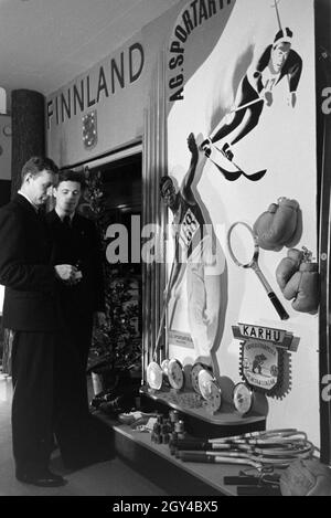 Zwei Besucher vor einem Ständer mit finnischen Sportartikeln auf der Leipziger Frühjahrsmesse, Deutschland 1941. Zwei Besucher vor einem stand der finnischen Sport waren auf der Leipziger Frühjahrsmesse, Deutschland 1941. Stockfoto