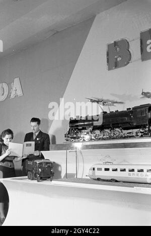 Zwei Personen vor einem Stand mit Modellen des italienischen Maschinenbau-Unternehmens Breda auf der Leipziger Frühjahrsmesse, Deutschland 1941. Zwei Personen vor einem Stand mit Modellen des italienischen Maschinenbaukonzerns Breda auf der Leipziger Frühjahrsmesse, Deutschland 1941. Stockfoto