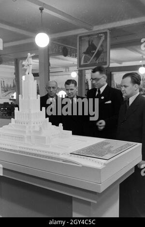 Besucher der Leipziger Frühjahrsmesse Vor Einem Modell Für Ein Sowjetisches Denkmal, Deutschland 1941. Besucher der Leipziger Frühjahrsmesse vor ein Architekturmodell eine sowjetische Denkmal Deutschland 1941. Stockfoto