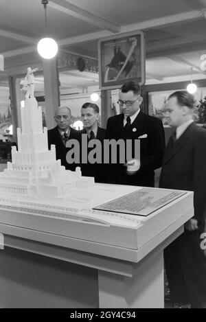 Besucher der Leipziger Frühjahrsmesse Vor Einem Modell Für Ein Sowjetisches Denkmal, Deutschland 1941. Besucher der Leipziger Frühjahrsmesse vor ein Architekturmodell eine sowjetische Denkmal Deutschland 1941. Stockfoto