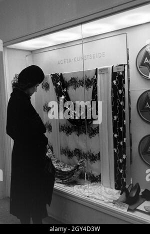 Messebesuch vor einem Schaukasten mit Aceta-Kunstseide von dem Konzerns I.G. Farbenindustrie, anlässlich der Wiener Modewoche im Haus der Mode ' Palais Lobkowitz', Deutschland 1940er Jahre. Besucher einer Messe vor einer Vitrine mit Aceta-Kunstseide der Firma I.G. Farbenindustrie, anlässlich der Wiener Modewoche im Haus der Mode ' Palais Lobkowitz', Deutschland 1940er Jahre. Stockfoto