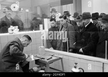 Besucher der Wiener Modewoche, im Haus der Mode 'Palais Lobkowitz', sahen einen Schweißer bei der Arbeit, Deutschland 1940er Jahre. Besucher der Wiener Modewoche im Haus der Mode 'Palais Lobkowitz' beobachten einen Schweißer bei der Arbeit, Deutschland 1940er Jahre. Stockfoto