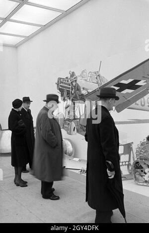 Besucher der Wiener Modewoche, im Haus der Mode 'Palais Lobkowitz', betrachten Ausstellungsstücke der Luftfahrttechnik, Deutschland 1940er Jahre. Die Besucher der Vienna Fashion Week im Haus der Mode 'Palais Lobkowitz' sehen sich Exponate der Luftfahrttechnik an; Deutschland der 1940er Jahre. Stockfoto