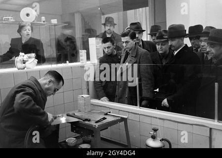 Besucher der Wiener Modewoche, im Haus der Mode 'Palais Lobkowitz', sahen einen Schweißer bei der Arbeit, Deutschland 1940er Jahre. Besucher der Wiener Modewoche im Haus der Mode 'Palais Lobkowitz' beobachten einen Schweißer bei der Arbeit, Deutschland 1940er Jahre. Stockfoto