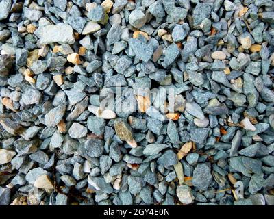 Grauer Boden Steinschutt Hintergrund von vielen kleinen Steinen. Stockfoto