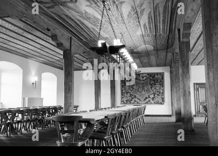 Ansicht eines Saals mit langer Tafel, Kronleuchter und Dekorationen/Reichsadler/Adler Motiv auf der Holzdecke und Teppich/Bild-an-der-Wand, Deutschland 1930er Jahre. Blick auf eine Halle mit einem langen Tisch, Kronleuchter und Dekorationen/Imperial eagle/Adler Motiv auf der Holzdecke und Tapestry/Bild an der Wand hängen, Deutschland 1930. Stockfoto