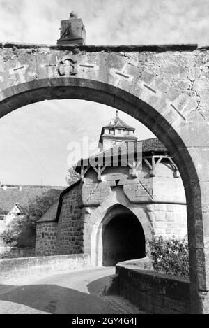 Blick durch einen Torbogen auf die historischen Bauwerke in Rothenburg o.d. Tauber, Deutschland 1930er Jahre. Blick durch einen Torbogen auf die historischen Gebäude in Rothenburg o.d. Tauber, Deutschland 1930. Stockfoto