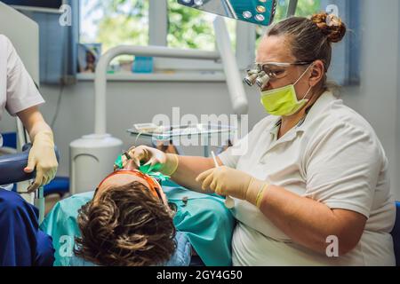 Mann, der Zähne bei Zahnärzten untersucht hat. Zahnärztliche Behandlung in der Zahnmedizin. Termin beim Zahnarzt. Lifestyle, echtes Leben Stockfoto