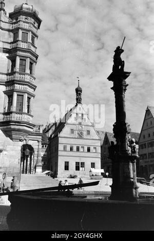Der Springbrunnen am Marktplatz vor dem imposanten Rathaus und der Ratstrinkstube, Rothenburg o.d. Tauber, Deutschland 1930er Jahre. Der Brunnen auf dem Marktplatz in der Nähe des imposanten Rathaus und Ratstrinkstube in Rothenburg o.d. Tauber, Deutschland 1930. Stockfoto