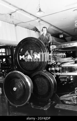 Eine Arbeiterin Rotationsdruckmaschine kontrolliert Sterben in den Werken des Maschinenbaukonzerns MAN (Maschinenfabrik Augsburg-Nürnberg), Deutschland 1930er Jahre. Ein Arbeitnehmer, der die Steuerung der Rotationsdruckmaschine, die in den Anlagen der mechanischen Engineering Company MAN (Maschinenfabrik Augsburg-Nürnberg), Deutschland 1930. Stockfoto