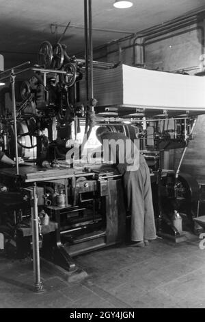 Ein Drucker setzt Lettern zu einem Schriftstatz Eine einer Rotationsdruckmaschine zusammen, Deutschland 1930er Jahre. Ein Drucker ist die Anordnung aus Metall Art auf einer Rotationsdruckmaschine, Deutschland 1930. Stockfoto