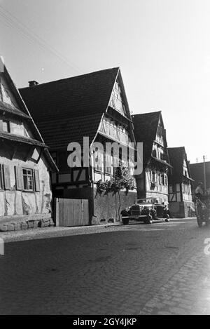 Eine Straße mit Fachwerkhäusern in Bruchsal, Deutschland 1930er Jahre. Eine Straße mit Fachwerkhaus Gebäude in Bruchsal, Deutschland 1930. Stockfoto