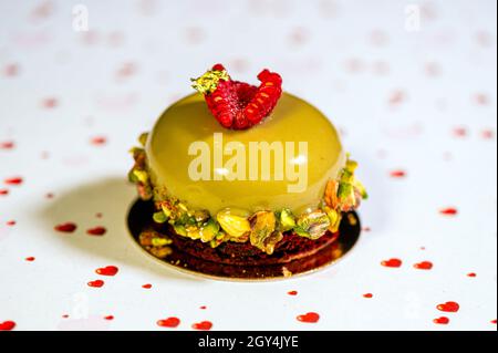 Selbstgebackene Avocado-Torte mit Sahnehäubchen, süßer Creme und Nüssen auf weißem Hintergrund mit Herzen, Nahaufnahme Stockfoto