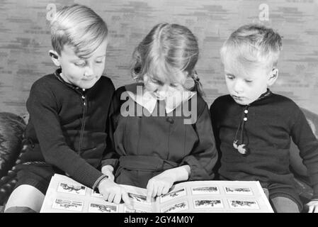 Mitglieder einer kinderreichen Familie schulmeisterschaft sich gemeinsam ein Fotoalbum ein, Deutsches Reich 30er Jahre. Mitglieder einer Großfamilie zu einem Fotoalbum suchen, Deutschland 1930. Stockfoto