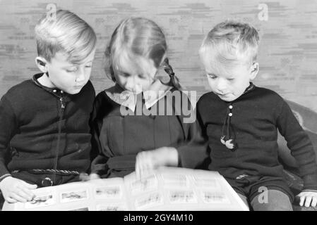 Mitglieder einer kinderreichen Familie schulmeisterschaft sich gemeinsam ein Fotoalbum ein, Deutsches Reich 30er Jahre. Mitglieder einer Großfamilie zu einem Fotoalbum suchen, Deutschland 1930. Stockfoto