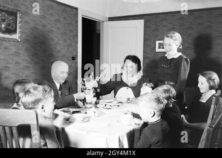 Mitglieder einer kinderreichen Familie bei Kaffe und Kuchen, Deutsches Reich 30er Jahre. Mitglieder einer Großfamilie mit Kaffee und Kuchen, Deutschland 1930. Stockfoto