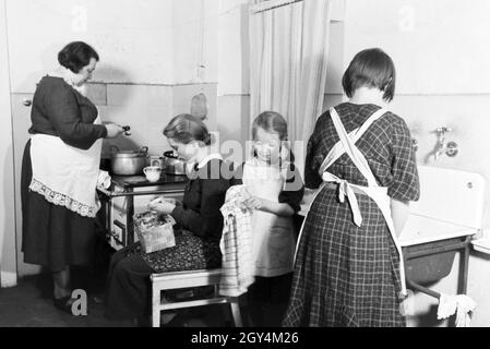 Mitglieder einer kinderreichen Familie bei der Hausarbeit, Deutsches Reich 30er Jahre. Mitglieder der Großfamilie, die Hausarbeit, Deutschland 1930. Stockfoto