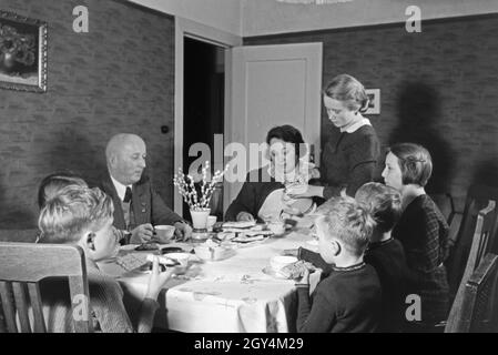 Mitglieder einer kinderreichen Familie bei Kaffe und Kuchen, Deutsches Reich 30er Jahre. Mitglieder einer Großfamilie mit Kaffee und Kuchen, Deutschland 1930. Stockfoto