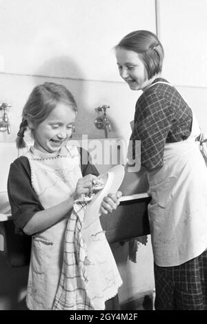 Mitglieder einer kinderreichen Familie bei der Hausarbeit, Deutsches Reich 30er Jahre. Mitglieder der Großfamilie, die Hausarbeit, Deutschland 1930. Stockfoto