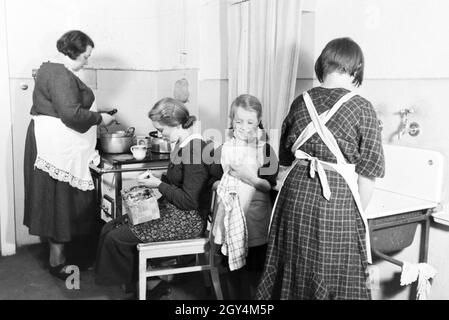 Mitglieder einer kinderreichen Familie bei der Hausarbeit, Deutsches Reich 30er Jahre. Mitglieder der Großfamilie, die Hausarbeit, Deutschland 1930. Stockfoto