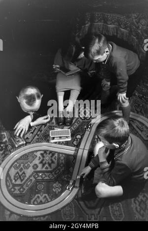 Mitglieder einer kinderreichen Familie spielen im Wohnzimmer, Deutsches Reich 30er Jahre. Mitglieder einer Familie spielen im Wohnzimmer, Deutschland 1930. Stockfoto