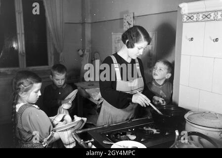 Mitglieder einer kinderreichen Familie bei der Hausarbeit, Deutsches Reich 30er Jahre. Mitglieder der Großfamilie, die Hausarbeit, Deutschland 1930. Stockfoto