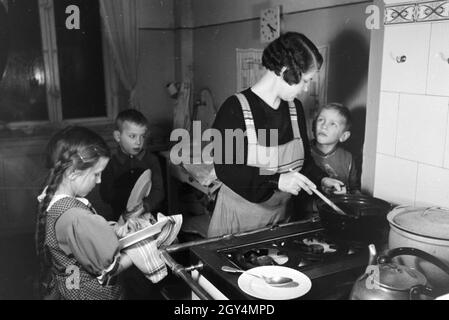 Mitglieder einer kinderreichen Familie bei der Hausarbeit, Deutsches Reich 30er Jahre. Mitglieder der Großfamilie, die Hausarbeit, Deutschland 1930. Stockfoto