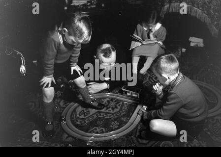 Mitglieder einer kinderreichen Familie spielen im Wohnzimmer, Deutsches Reich 30er Jahre. Mitglieder einer Familie spielen im Wohnzimmer, Deutschland 1930. Stockfoto