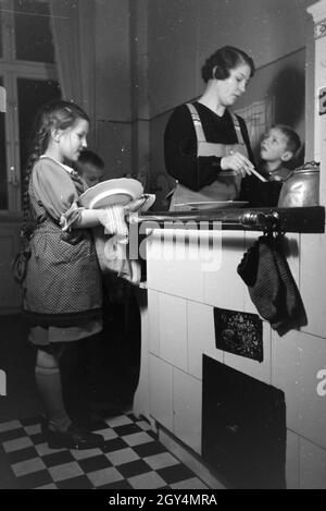 Mitglieder einer kinderreichen Familie bei der Hausarbeit, Deutsches Reich 30er Jahre. Mitglieder der Großfamilie, die Hausarbeit, Deutschland 1930. Stockfoto