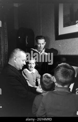 Mitglieder einer kinderreichen Familie beim Klavierspielen, Deutsches Reich 30er Jahre. Mitglieder der Großfamilie, Klavier spielen, Deutschland 1930. Stockfoto