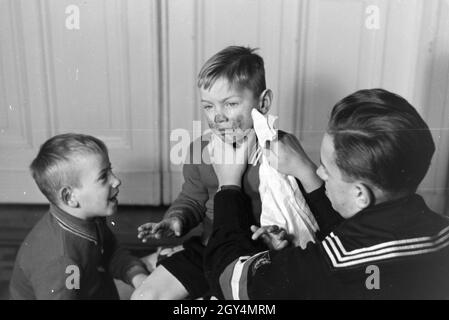 Mitglieder einer kinderreichen Familie helfen sich gegenseitig, Deutsches Reich 30er Jahre. Mitglieder einer Großfamilie gegenseitig helfen, Deutschland 1930. Stockfoto