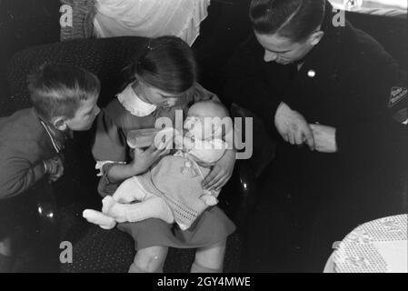 Mitglieder einer kinderreichen Familie mit dem Neugeborenen, Deutsches Reich 30er Jahre. Mitglieder der Großfamilie, mit dem neugeborenen Baby, Deutschland 1930. Stockfoto