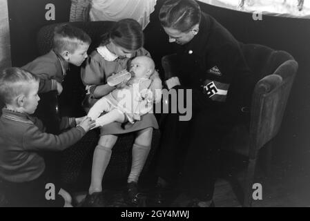 Mitglieder einer kinderreichen Familie mit dem Neugeborenen, Deutsches Reich 30er Jahre. Mitglieder der Großfamilie, mit dem neugeborenen Baby, Deutschland 1930. Stockfoto