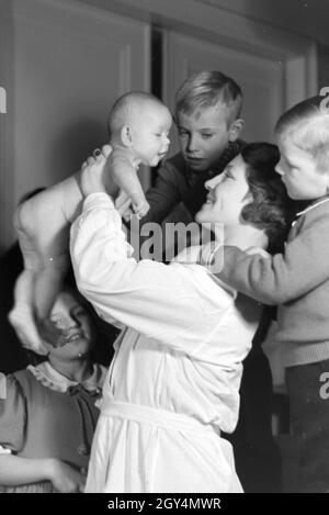 Mitglieder einer kinderreichen Familie mit dem Neugeborenen, Deutsches Reich 30er Jahre. Mitglieder der Großfamilie, mit dem neugeborenen Baby, Deutschland 1930. Stockfoto