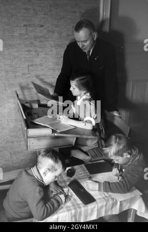 Mitglieder einer kinderreichen Familie helfen sich gegenseitig, Deutsches Reich 30er Jahre. Mitglieder einer Großfamilie gegenseitig helfen, Deutschland 1930. Stockfoto