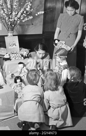 Kinder, ein Mädchen in japanischer Tracht, bei einer Ausstellung der Reichsfrauenführung, Deutschland 1930er Jahre. Kinder, eines davon ein Mädchen in traditionellen japanischen Array, auf einer Ausstellung der Reichsfrauenführung, der NS-Frauen Organisation, Deutschland 1930. Stockfoto