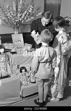 Zwei Kinder, ein Mädchen in japanischer Tracht, bei einer Ausstellung der Reichsfrauenführung, Deutschland 1930er Jahre. Twi Kinder, eines davon ein Mädchen in traditionellen japanischen Array, auf einer Ausstellung der Reichsfrauenführung, der NS-Frauen Organisation, Deutschland 1930. Stockfoto