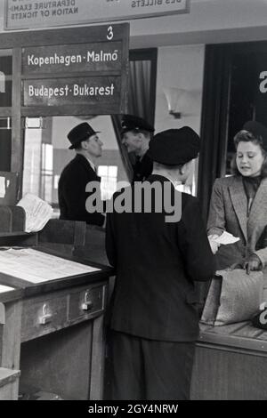 Eine Passagierin mit einem Zollbeamten auf dem Flugplatz Tempelhof in Berlin, Deutschland, 1930er Jahre. Ein weiblicher Passagier mit einem Zollbeamten am Flughafen Berlin Tempelhof, Deutschland 1930. Stockfoto