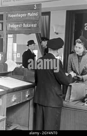 Eine Passagierin mit einem Zollbeamten auf dem Flugplatz Tempelhof in Berlin, Deutschland, 1930er Jahre. Ein weiblicher Passagier mit einem Zollbeamten am Flughafen Berlin Tempelhof, Deutschland 1930. Stockfoto