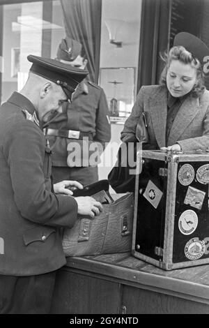 Eine Passagierin mit einem Zollbeamten auf dem Flugplatz Tempelhof in Berlin, Deutschland, 1930er Jahre. Ein weiblicher Passagier mit einem Zollbeamten am Flughafen Berlin Tempelhof, Deutschland 1930. Stockfoto