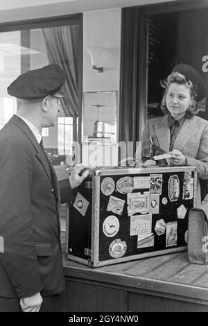 Eine Passagierin mit einem Zollbeamten auf dem Flugplatz Tempelhof in Berlin, Deutschland, 1930er Jahre. Ein weiblicher Passagier mit einem Zollbeamten am Flughafen Berlin Tempelhof, Deutschland 1930. Stockfoto