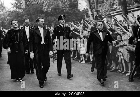 Der Festivaldirektor und Hitler-Loyalist Winifred Wagner, Hitlers Lagerberater Julius Schaub und Adolf Hitler laufen an einer jubelnden Menge vorbei. Wagner blieb Hitler nach dem Krieg als alter Nazi öffentlich treu. [Automatisierte Übersetzung] Stockfoto