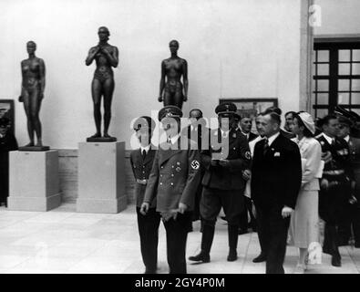 „Adolf Hitler auf einer Führung durch die große deutsche Kunstausstellung 1938“ im Haus der Deutschen Kunst (heute Haus der Kunst) mit Joseph Goebbels (links). Die Dame in Weiß ist Gerdy Troost, mit Adjutant Julius Schaub rechts. [Automatisierte Übersetzung]' Stockfoto