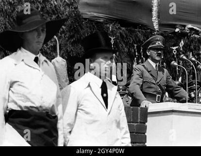 Neben Adolf Hitler stehen Steinmetze und Maurer im Zunftkleid, der bei der Grundsteinlegung der Kraft durch Freude Wagen Fabrik eine Rede hält. [Automatisierte Übersetzung] Stockfoto